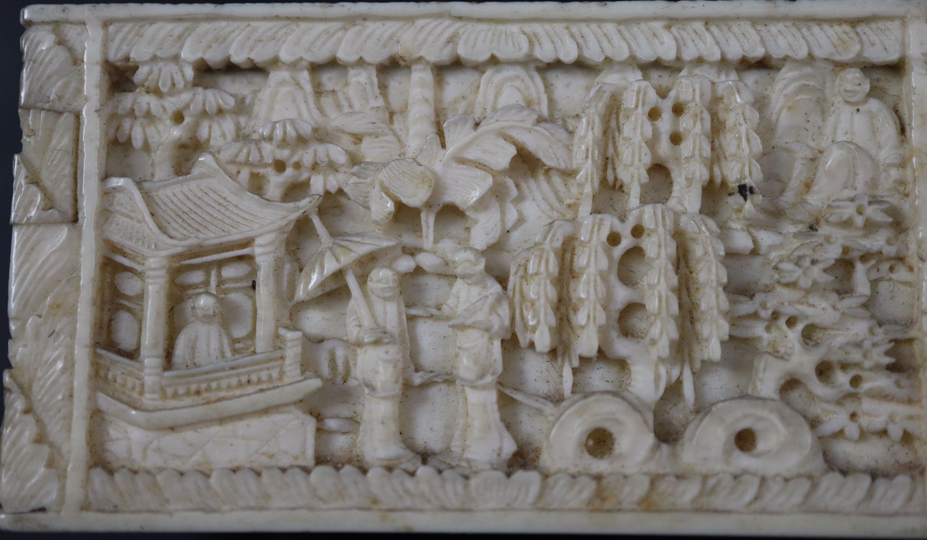 A 19th century Chinese relief carved ivory box housing plain and red stained ivory alphabet letters, 6.75cm